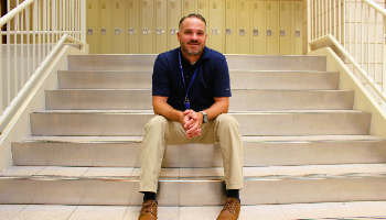 Mr Mays sits on stairs