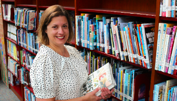 Mrs Jurkynas stands in the library