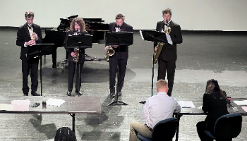 Students performing on a stage for evaluators