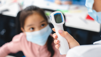 a school nurse takes a child's temperature