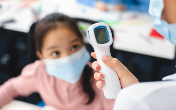 school nurse takes child's temperature