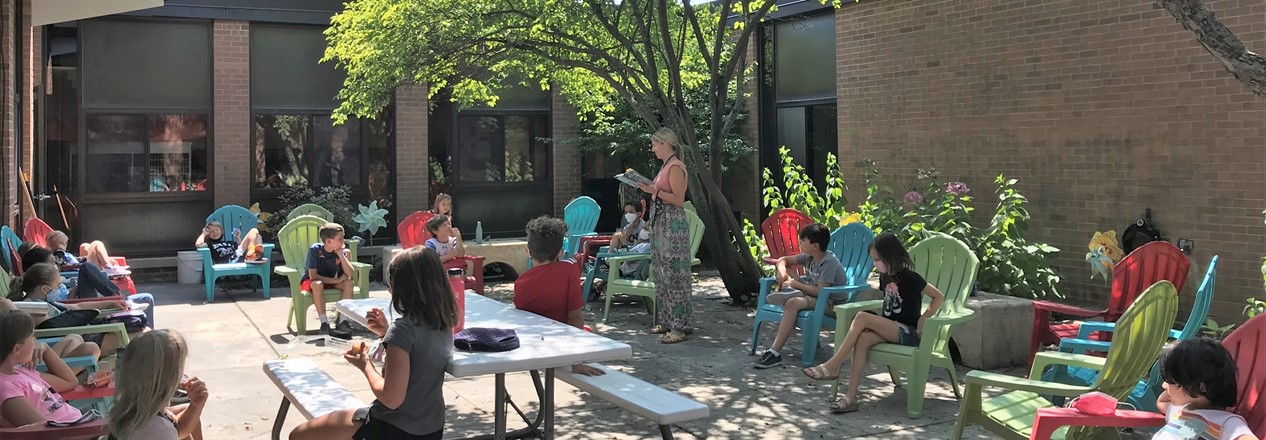 Teacher Reads to Students in Courtyard