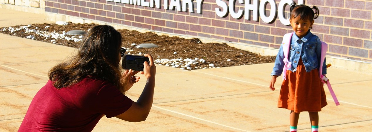 Posing by the school sign